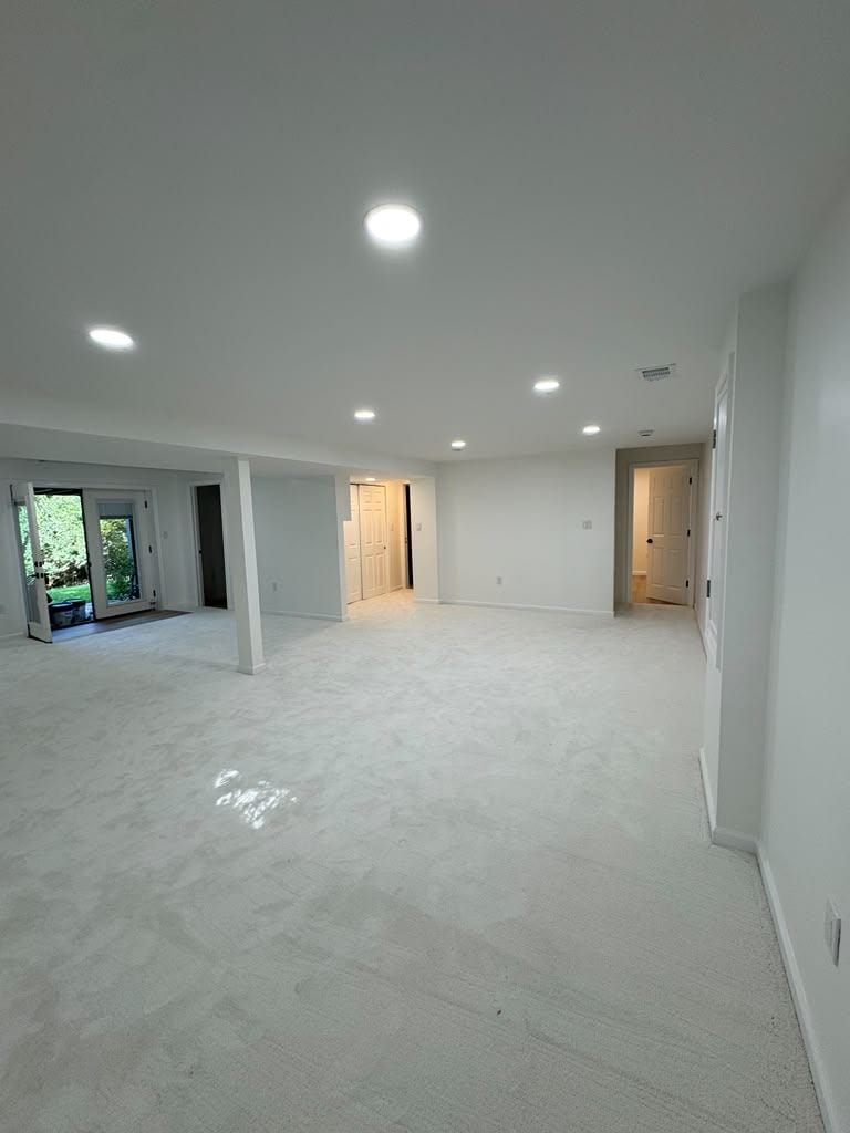 Large finished basement with recessed lighting and a walk-out door