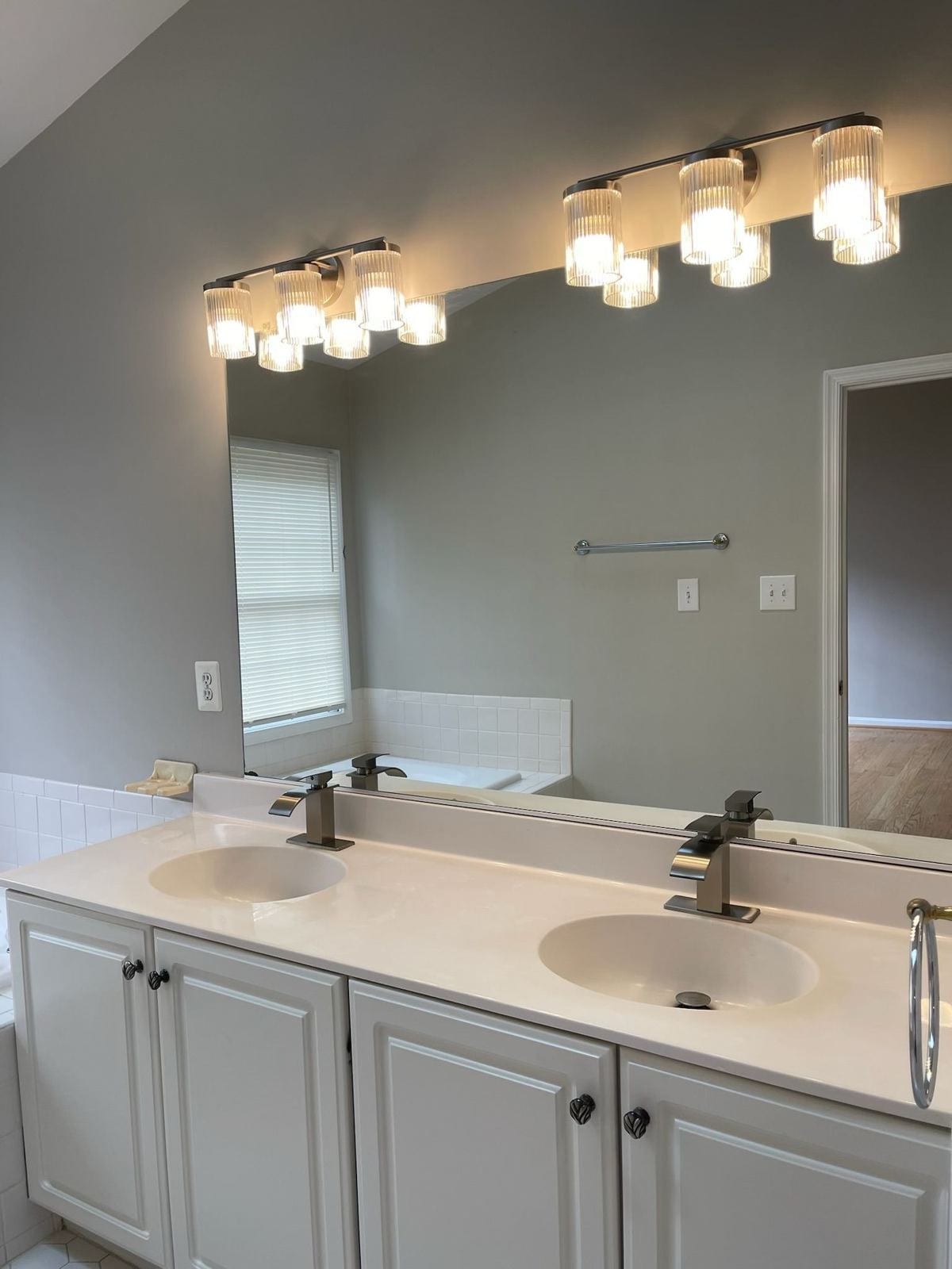 Updated double vanity with new light fixtures in a renovated bathroom